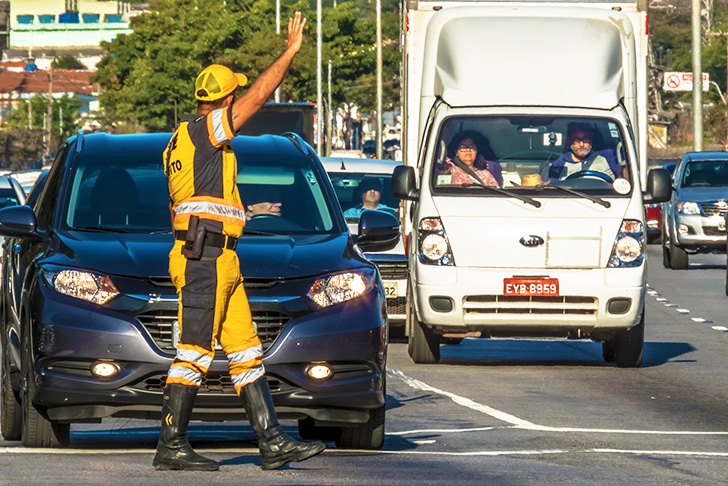 Guarda de trânsito orientando motoristas.