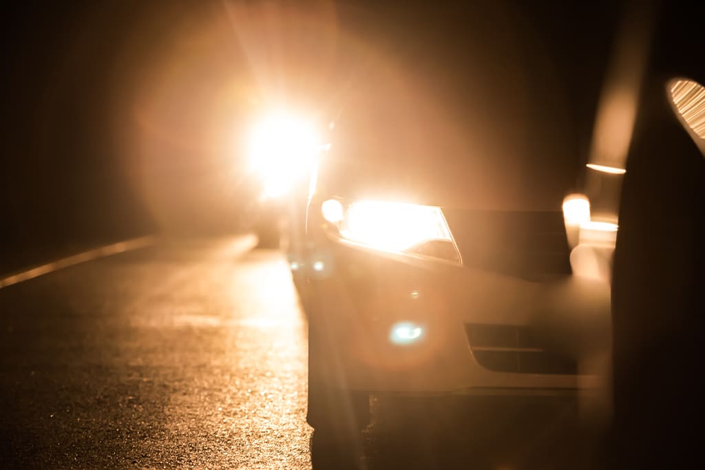 Farol aceso em rodovia durante a noite
