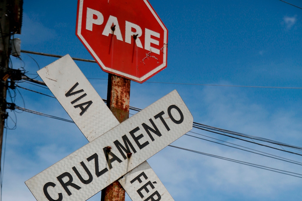 Placas de pare também são complementadas por avisos de cruzamentos em linhas férreas.