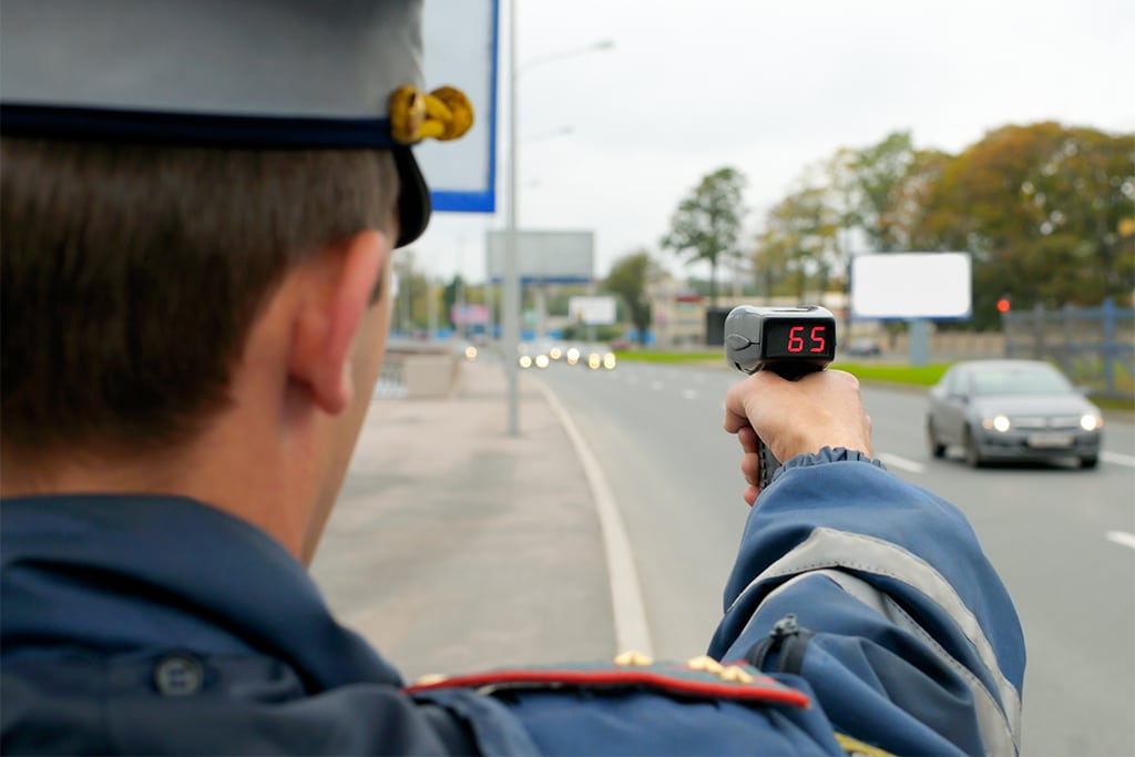 agente de trânsito segurando um radar de trânsito portátil