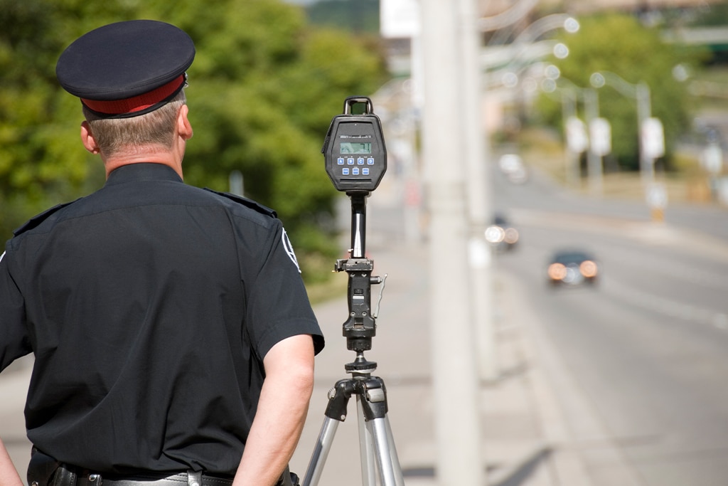 agente de trânsito ao lado de um radar estático